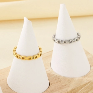 Nahaufnahme von gold- und silberfarbenen Ringen mit Zirkonia auf einem Holzständer