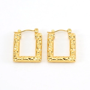 Detail of gold rectangular hoop earrings with a unique hammered texture finish