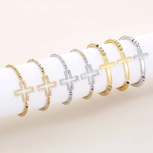 Gros plan de bracelets avec croix serties de zircons et chaînes à billes en acier