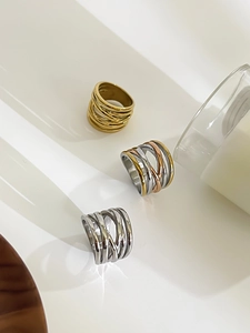 Detailed view of layered hollow woven stainless steel rings in gold, silver, and tricolor