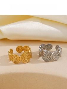 Detailed close-up of spiral textured gold and silver open rings on a satin backdrop