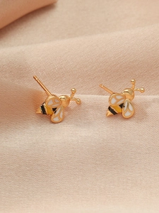Chic gold-plated bee stud earrings with yellow enamel stripes on champagne silk background