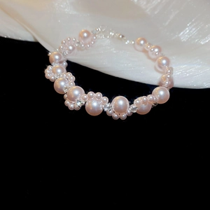 Macro detail of French style pearl bracelet with sparkling crystal accents on silk