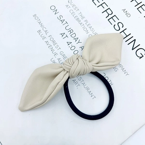 Elegant beige faux leather bow hair tie with a durable black elastic band
