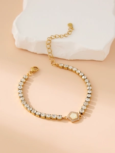 Detail of gold chain bracelet with hexagonal opal charm and sparkling cubic zirconia links