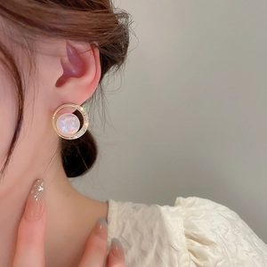 Elegant gold hoop earrings with iridescent pearls and cubic zirconia on a model