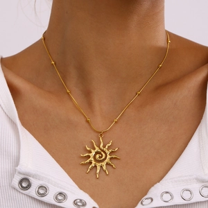 Golden stainless steel sun pendant necklace with small beads worn on a model
