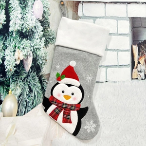 Close-up of a Christmas stocking featuring a 3D red penguin on grey felt and white faux fur