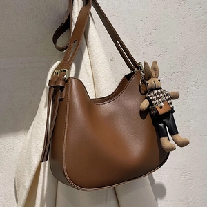 Chic brown leather shoulder bag with adjustable strap and cute bunny pendant charm