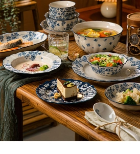 Classic blue and white porcelain tableware set displayed on a wooden table with food