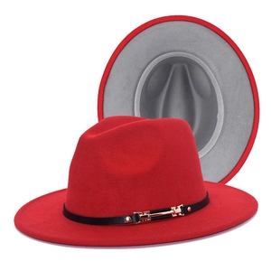 Detail view of red fedora hat with black leather band, gold buckle and grey lining