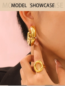 Polished gold hollow bamboo style C-shape earrings and chunky ring on model
