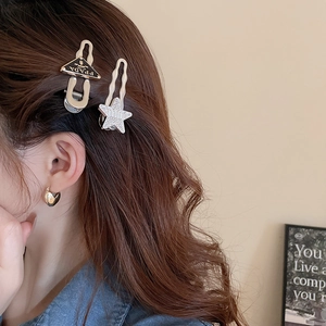 Detailed close-up of gold Y2K hair clips and heart earrings with sparkling rhinestones