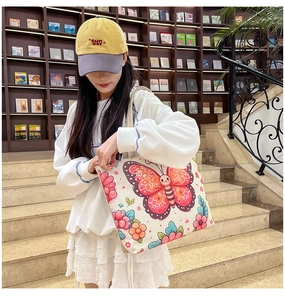 Ethnic style canvas tote bag featuring pink butterfly and flower print in a library setting