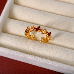 Close-up of 18k gold-plated open ring with red enamel butterflies in a white velvet box