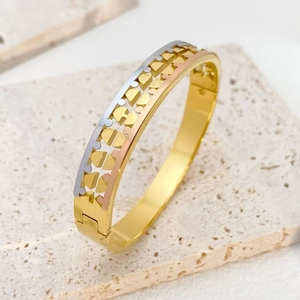 Three-tone stainless steel open bangle with hollow geometric patterns on stone