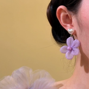 Detailed view of elegant purple fabric flower earrings with heart-shaped pearl studs