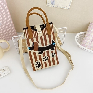 Close-up of knit crossbody bag featuring brown stripes and a black dachshund pattern