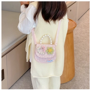 Close-up of pink lace girl's bag with pearl handle and rhinestone heart detail