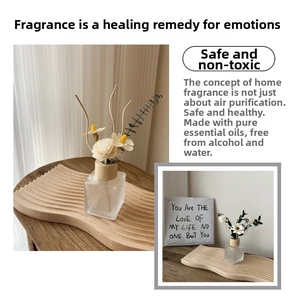 Minimalist reed diffuser set with frosted glass bottle and floral sticks on a wood tray