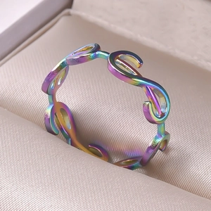 Macro detail of rainbow wave link stainless steel ring on beige fabric cushion