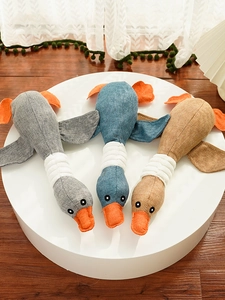 Detailed close-up of three plush duck pet toys in grey, blue, and brown corduroy texture