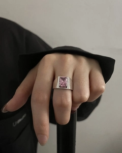 Macro detail of silver wide band ring featuring a pink emerald-cut zircon stone