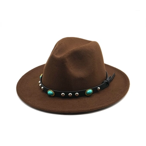 Dettaglio di un cappello jazz in feltro marrone con pietre turchesi e borchie
