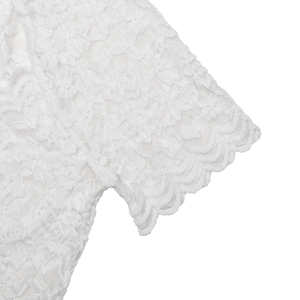 Detailed close-up of white floral lace texture and scalloped hem on a woman's bodysuit