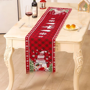 Red and black plaid Christmas table runner featuring gnomes and reindeer on a table