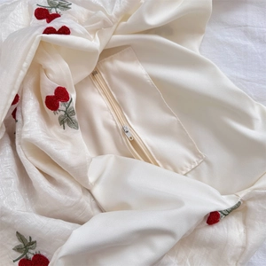 Detail of hidden zipper and delicate cherry embroidery on ivory tulle shoulder bag