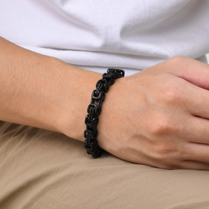 Detailed view of men's matte black Byzantine link bracelet worn on a wrist in close-up