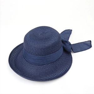 Detailed macro view of deep blue woven straw hat featuring a wide ribbed ribbon bow