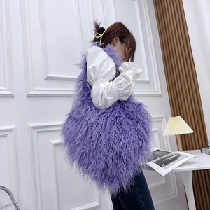 Detail view of purple faux fur heart bag styled with a white puff sleeve shirt