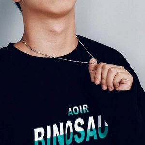 Gros plan d'un collier chaîne à billes en acier argenté porté par un mannequin