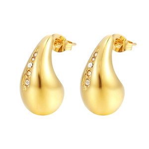 Macro shot of gold teardrop earrings featuring sparkling pavé zircons on polished steel