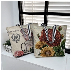 Close-up of vintage canvas tote bags with floral prints and striped woven handles