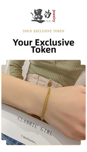 Detail of gold titanium steel wheat link chain bracelet worn on a female wrist