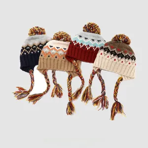 Close-up of four knit earflap hats with large pom-poms and hand-woven braided tassels