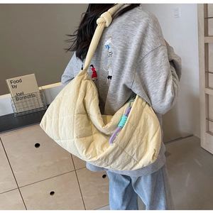 Detail of yellow quilted tote bag showing large capacity and knotted shoulder strap