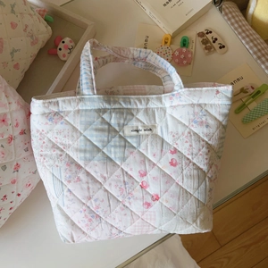 Close-up of quilted floral and plaid patchwork fabric with Simple Wish label on tote bag