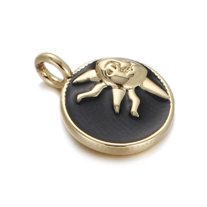 Detail of a gold plated sun pendant with a black enamel inlay and circular relief motif