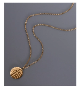 Close-up of golden Chinese Fu pendant on a fine 18K gold-plated titanium steel chain
