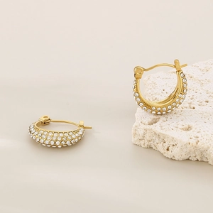 French vintage gold U-shaped paved zircon hoop earrings on a minimalist white stone base