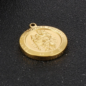 Macro shot of gold stainless steel Saint Christopher pendant with embossed detail