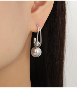 Macro shot of silver minimalist drop earrings with two high-polished metal spheres