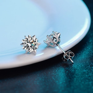 Macro view of 925 silver moissanite stud earring in sunburst setting on a white plate