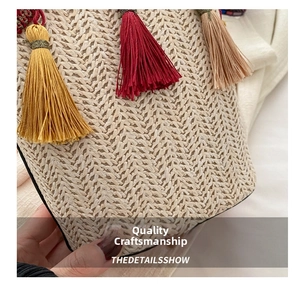 Macro detail of hand-woven straw bucket bag featuring colorful tassels and herringbone texture
