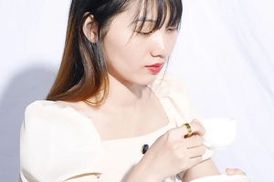 Golden Roman numeral hollow ring worn by a model holding a white coffee cup
