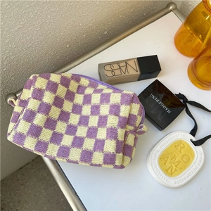 Purple and yellow checkered knit makeup bag with zipper closure on a white surface